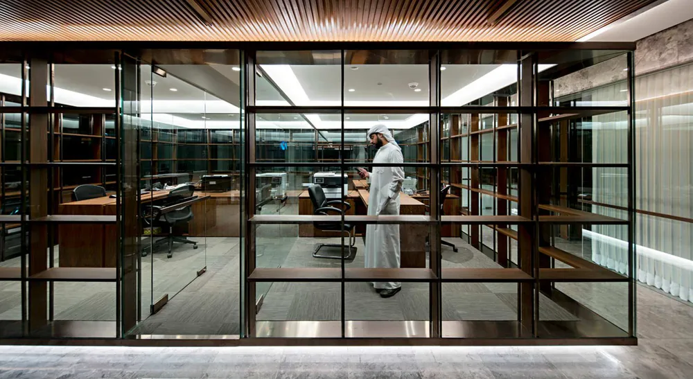 A man standing in a glass-walled office